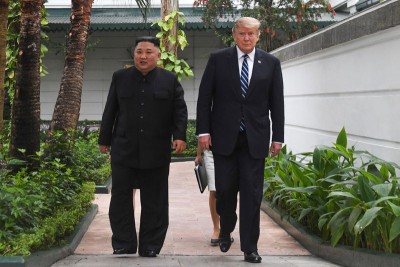 金正恩（左）与特朗普在举行峰会的大都市索菲特传奇酒店花园内散步。（法新社照片）