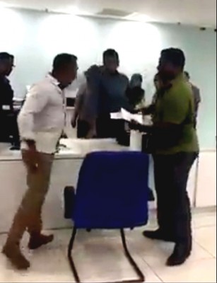 男子（左）朝政府部门单位的柜台人员发飙，旁边一名男子上前试图拉开他。（视频截图）