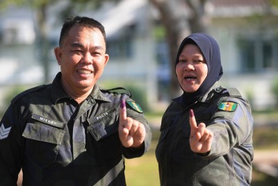 2名警察普通行动部队成员在投票后，展示他们“墨染”的手指。