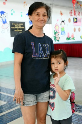 小妹妹跟着阿嫲念唱:“火金星,十五暝,请你的舅仔來食茶.....”.