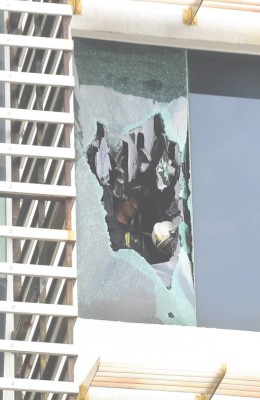 消拯人员敲破玻璃进入建筑物内。