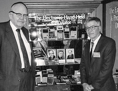 梅利曼（右）和诺贝尔奖得主基尔比（左）在他们发明的手持电子计算机前合影。